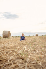 Naklejka na ściany i meble cute baby girl with a beautiful smile at wheat field.