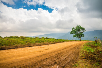 Rural road on top of mountain hill countryside in sunny day. Nature landscape, outdoor adventure concept. © pla2na