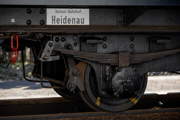 close-up shot of a railway bogie of a narrow gauge railroad waggon. Text on white reads...