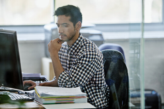 Coming up with a fool-proof plan. Cropped shot of a handsome young designer working on a pc.