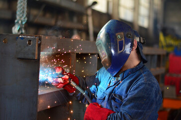 A welder works at a factory