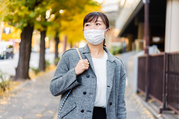 マスクをして街を歩く若い女性
