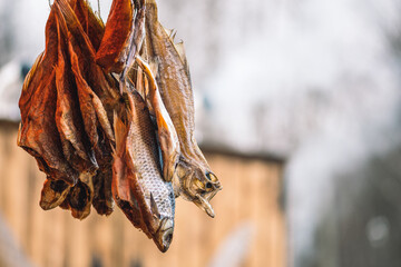 Dry salted fish in a regional street food market with smoke on background