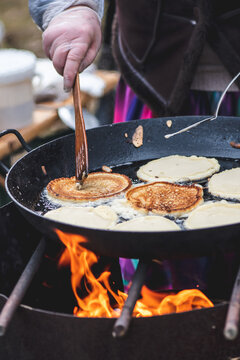 Blini, blin or blynai, pancakes traditionally made from wheat or buckwheat flour and served with smetana, tvorog, butter, caviar and other garnishes, preparing outdoor on an open fire