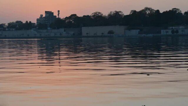 Sunset timelapse of calm river water with sun going down in sky. At Sabarmati river front in Ahmedabad, Gujarat, India. Sunset lake. 