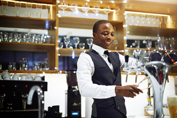 I show all my customers a good time. Cropped shot of a well-dressed bartender standing behind the counter.