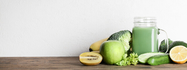 green smoothie in glass bottle with vegetables on wooden and white background. vegan food and healthy lifestyle. detox diet. copy space. banner