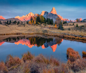 Cimon della Pala peak reflected in the calm waters of small mountain lake. Stunning autumn view of...