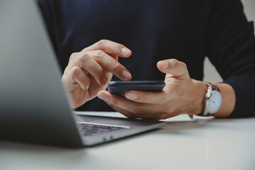 Hand of young business using smart phone at home office, Relax and entertainment concept.