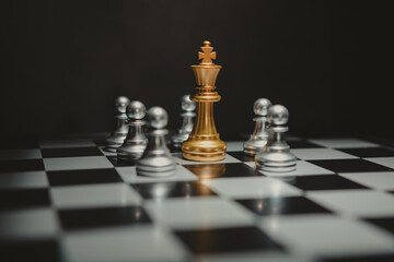The golden chess king leads the silver chess pieces on the chessboard, business, success, competition,Teamwork and leadership concept.