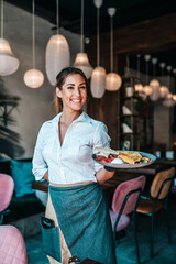 Beautiful young waitress serving delicious omelet.