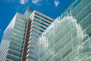 Exterior mirror glass of modern office building with blue sky background. Detail abstract pattern of building and architecture concept.