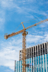 Tower crane in modern building construction site. Construction industry concept.