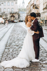 An international wedding couple, a European bride and an Asian groom walk around the city together.