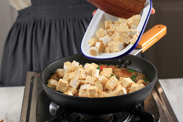 Put Tempeh (Tempe) to the Pan, Indonesian Traditional Food Made from Fermented Soy Bean.