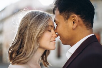 An international wedding couple, a European bride and an Asian groom walk around the city together.