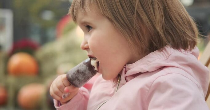 Cute little baby girl eating delicious ice cream