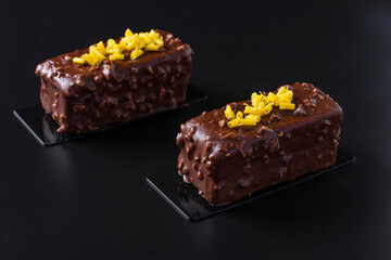 Two Chocolate Almond Brownie covered gourmet chocolate glaze on black background