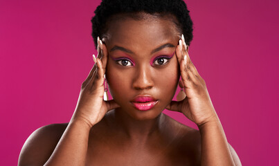 Once Im focused ,I go for what I want. Studio shot of a beautiful young woman posing against a pink background.