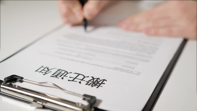 eviction notice in Chinese-speaking language. A person's hand signs a document. A warning. He is deprived of property, a mortgage on a mortgage. 