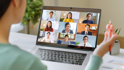 Young Asian businesswoman work at home and virtual video conference meeting with colleagues business people, online working, video call via computer laptop at home office