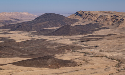Fototapeta na wymiar View of Ramon Crater with remanats of ancient volcanoes as seen from its most Western end as seen from Mount Ramon, located in the Negev Desert, south of Beer Sheba, Southern Israel, Israel.