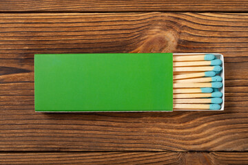 top view green color matchbox with green match sticks on a wood table