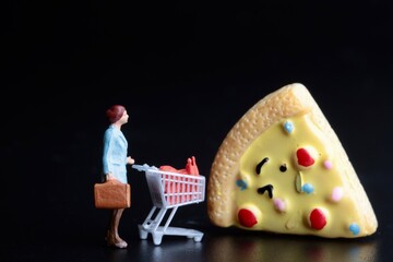 miniature figurine of a woman with a shopping cart buying a slice of pizza