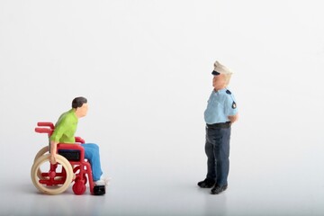police officer making a fine to a disabled man on a wheelchair - miniature people
