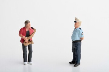 miniature figurine of a police officer taking a fine to street musician
