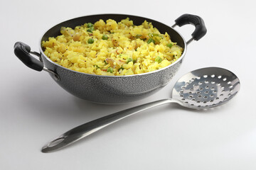 Indian Breakfast Dish Poha Also Know as Pohe or Aalu poha made up of Beaten Rice or Flattened Rice. The rice flakes are lightly fried in oil with mustard, turmeric, onion, curry leaves