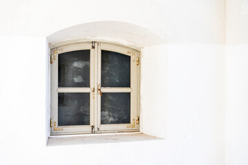 The old window of architecture of the XVII century on white wall