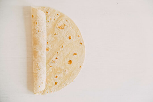 Thin pita bread on a white wooden table background