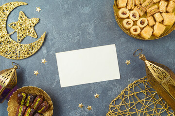 Greeting card mock up for Ramadan kareem holiday  with dried dates, Ramadan sweets and decorations. Top view, flat lay background