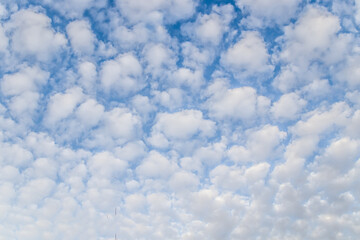 Beautiful fluffy clouds on a blue sky as a background.