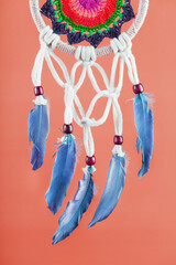 Amulet Dreamcatcher on a red background close-up protecting the sleeper