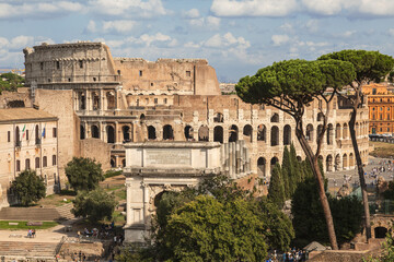 Obraz premium View of the ruins of the Roman Forum with the arch of Titus and the Colosseum. Rome, Italy