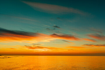 Naklejka na ściany i meble Beautiful cloudy sky at sunset on the sea