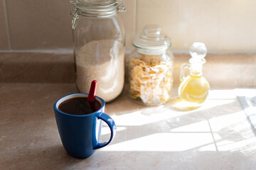 Blue cup of coffee in a kitchen in sunlight. Home concept.