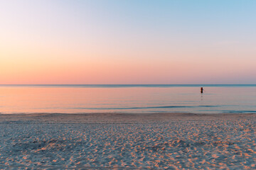 Clear and calm sunset on sea shore glowing pink