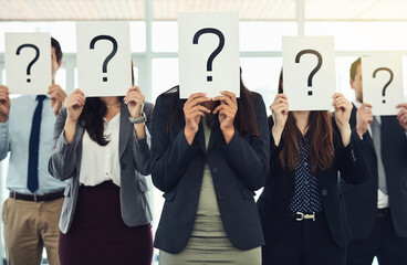 Do you have answers because we have questions. Shot of a group of businesspeople holding questions...