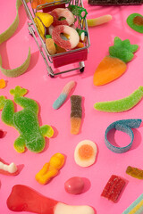 marmalade sweets, a background of various kinds of jelly sweets in the form of bears, ribbons, fruits and other toys. On a pink background