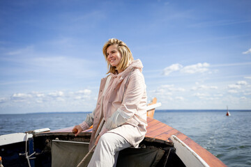 Young woman navigating sailboat sails on the lake