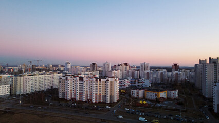 City block. Modern multi-storey buildings. Flying at dusk at sunset. Aerial photography.