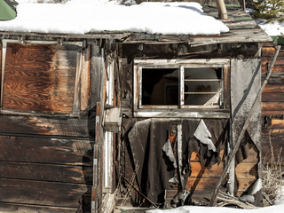 Abstract weathered dilapidated tarpaper shack side in winter