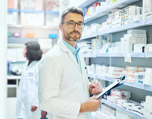 Medication is my expertise. Shot of a mature man doing inventory in a pharmacy with his colleague in the background.