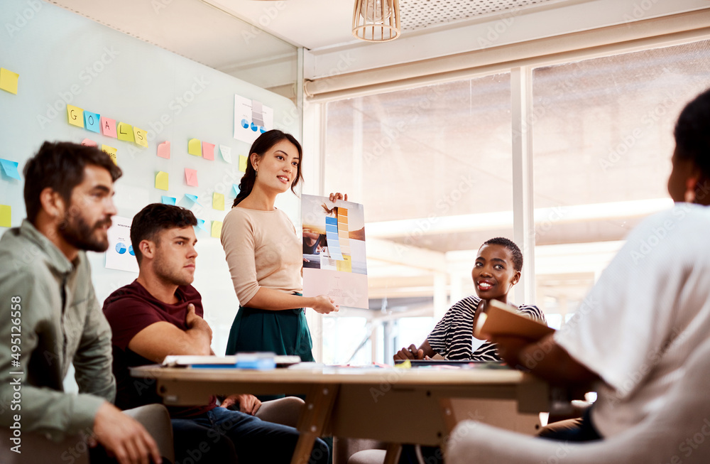 Poster Pushing the boundaries while retaining their own style. Shot of a group of young creatives having a meeting in an office.