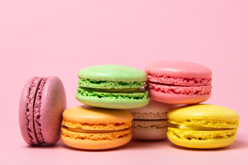 Fototapeta na wymiar Colored macarons on a pink background. Light and tasty dessert. traditional dessert