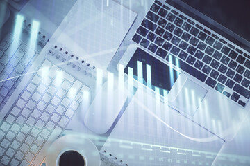 Financial market graph and top view computer on the desktop background. Multi exposure. Investment concept.