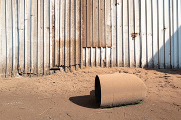 Discarded metal funnel located outside a grain store and process facility. Grain kernels have...